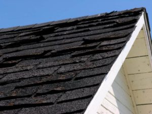 cracked shingles on roof in need of repair